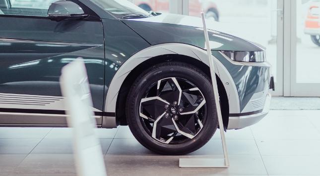 Vorderansicht eines Hyundai Ioniq 5 im Autohaus, Fokus auf Rad und Felge.